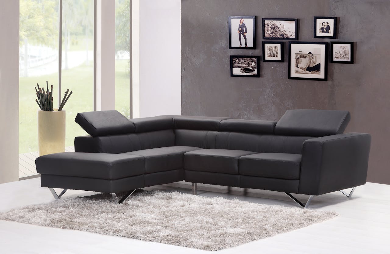 Home Contemporary living room featuring a sleek black sectional sofa and chic wall art.